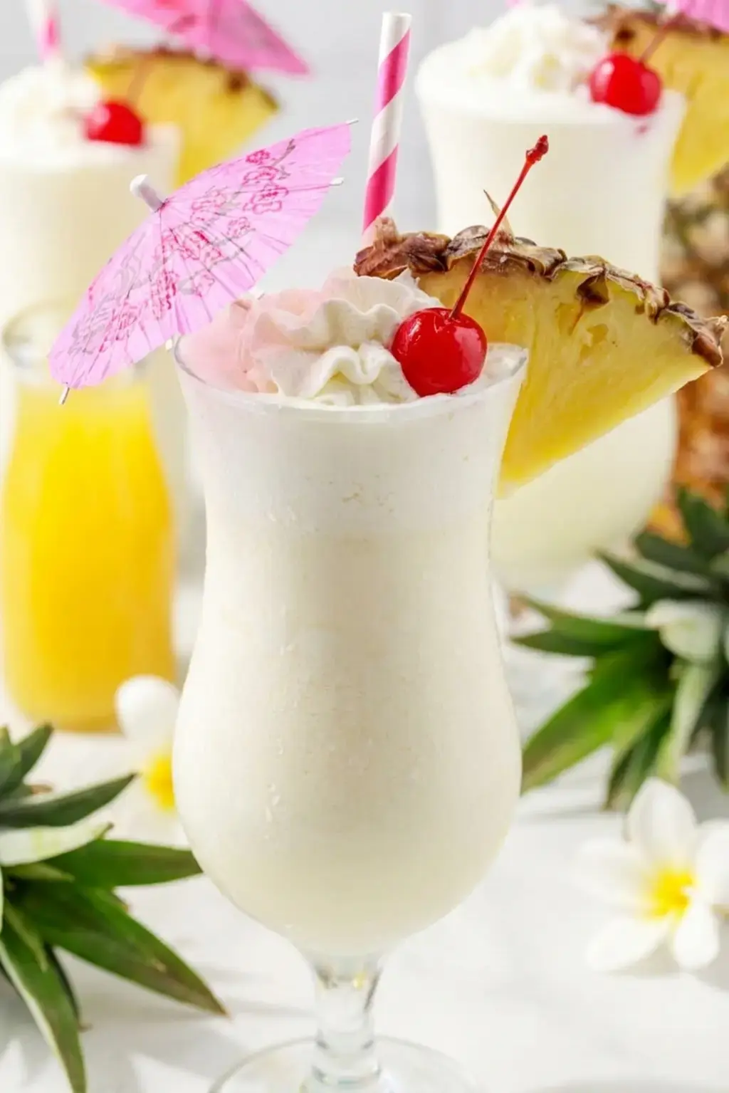Two creamy frozen pina colada cocktails with pineapple garnish
