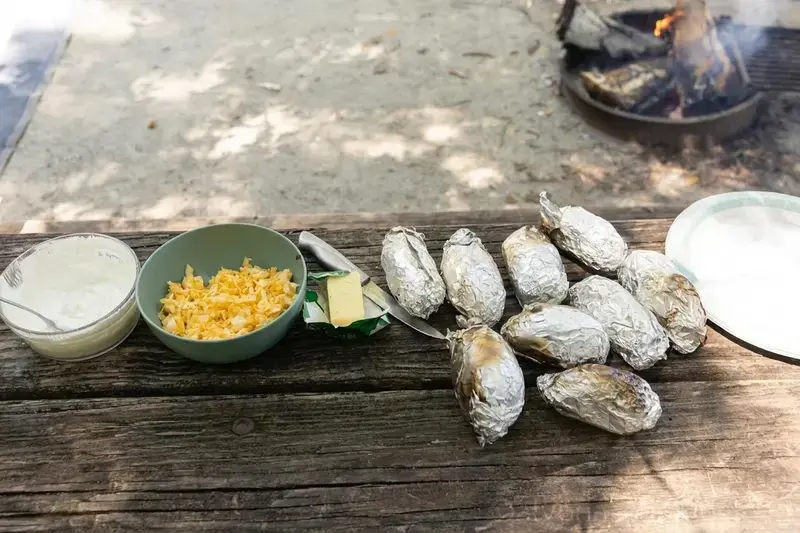 Campfire Baked Potatoes With Easy Loaded Toppings 12 Cooked campfire potato resting in its foil packet