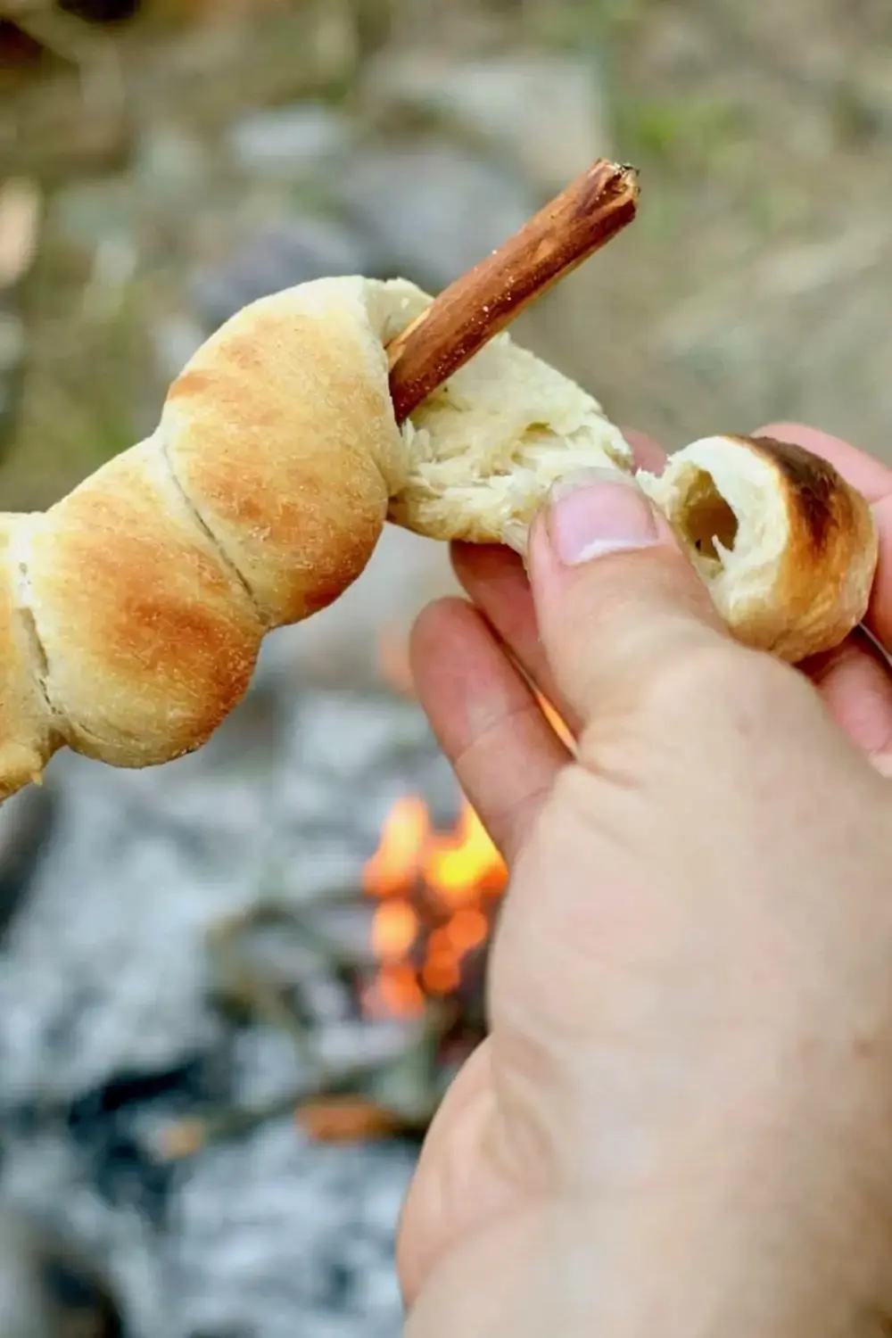 Golden campfire bread cooling on its stick
