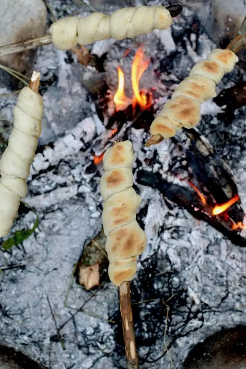 Bread dough wrapped around a long roasting stick
