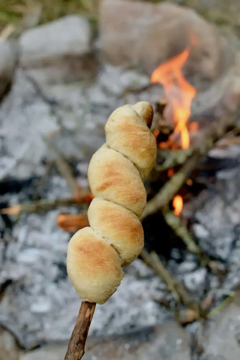 Long dough strip twisted securely around a stick