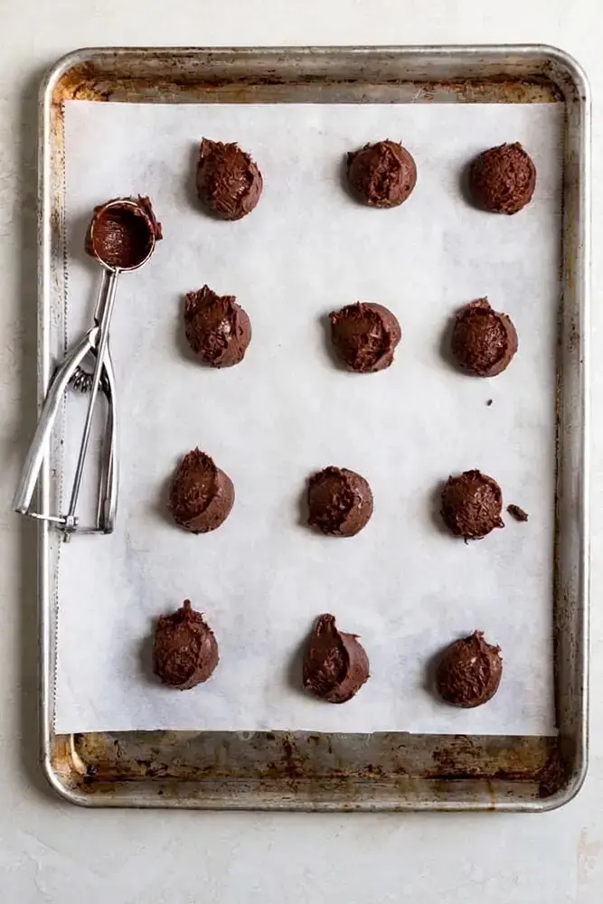 Chocolate Brownie Cookies: Recipe, Method, and Tips 5 Loose brownie cookie batter portioned on parchment