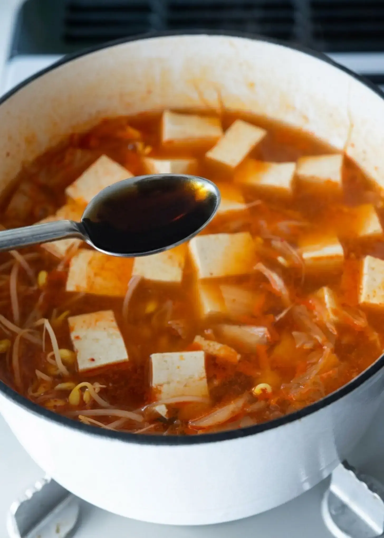 Korean seasoning being stirred into the soup