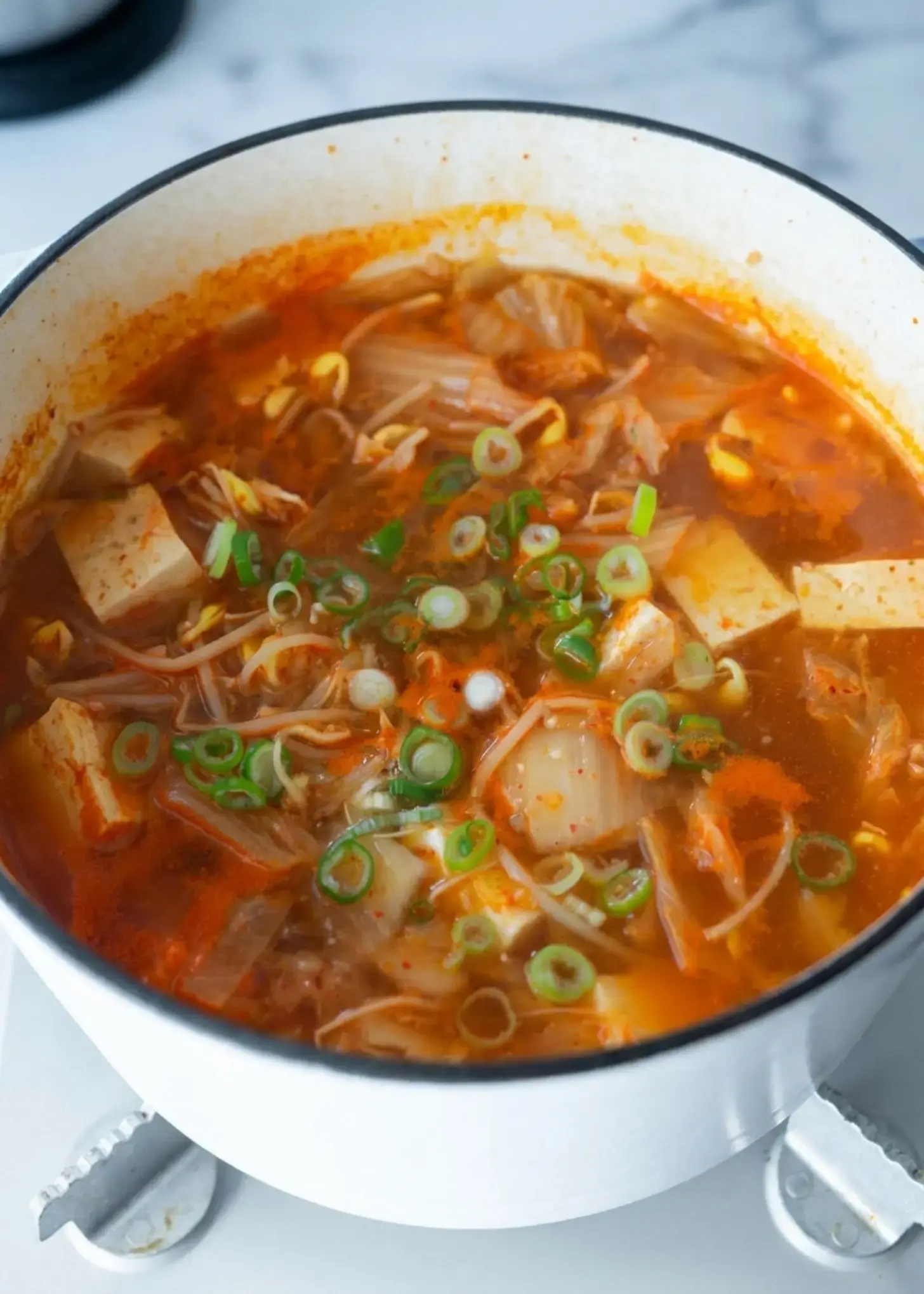 Kimchi bean sprout soup gently simmering with tofu