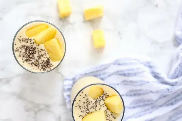 Pina colada smoothie ingredients added to a blender