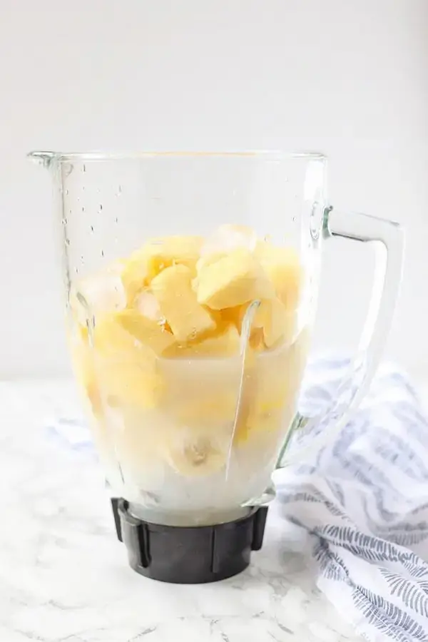 Pineapple banana and coconut milk blending smoothly