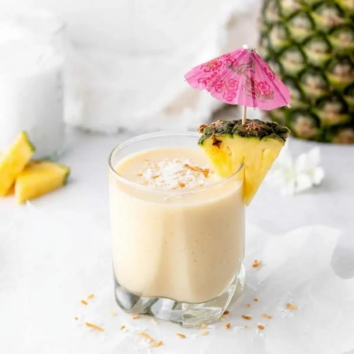 Tropical Almond Colada Smoothie With Pineapple and Coconut 7 Creamy tropical smoothie being poured into a glass